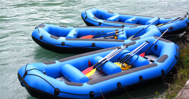 a blue and white boat sitting next to a body of water