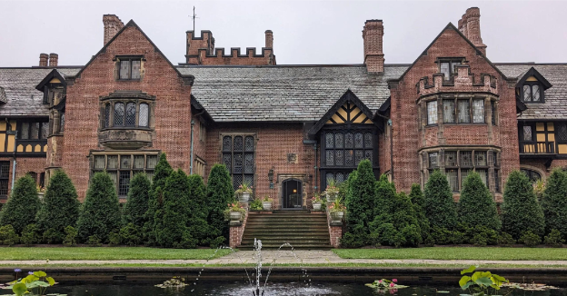 a bench in front of a house with Moseley Old Hall in the background